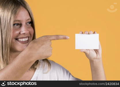 smiling disable young woman pointing blank visiting card