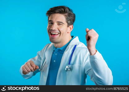 Smiling doctor funny dancing, success and luck at work. Young handsome doc man in professional medical white coat is isolated on blue studio background. High quality photo. Smiling doctor funny dancing, success and luck at work. Young handsome doc man in professional medical white coat is isolated on blue studio background.