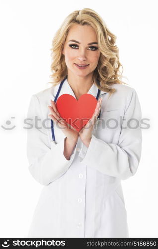 Smiling doctor holding paper heart. Smiling female doctor holding heart shape paper studio portrait isolated on white background