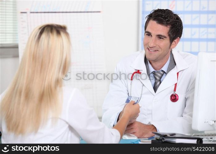 Smiling doctor taking patient&rsquo;s card