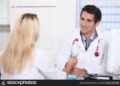 Smiling doctor taking patient&rsquo;s card