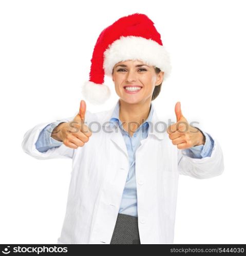 Smiling doctor woman in santa hat showing thumbs up