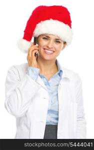 Smiling doctor woman in santa hat talking cell phone