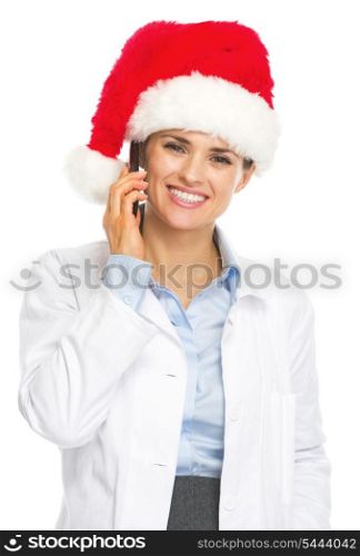 Smiling doctor woman in santa hat talking cell phone