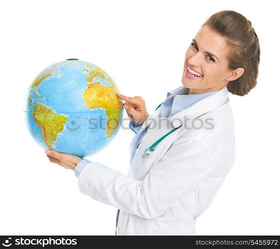 Smiling doctor woman pointing in earth globe
