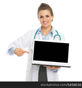 Smiling doctor woman pointing in laptops blank screen