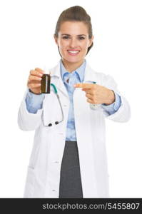 Smiling doctor woman pointing on medicine bottle