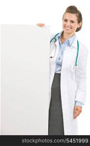 Smiling doctor woman showing blank billboard