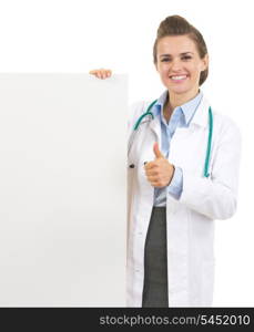 Smiling doctor woman showing blank billboard and thumbs up