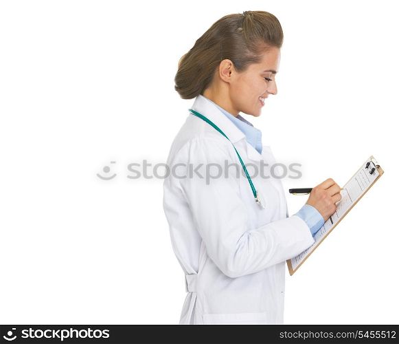 Smiling doctor woman writing in clipboard
