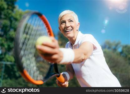 Smiling Elderly Woman Playing Tennis as a Recreational Activity