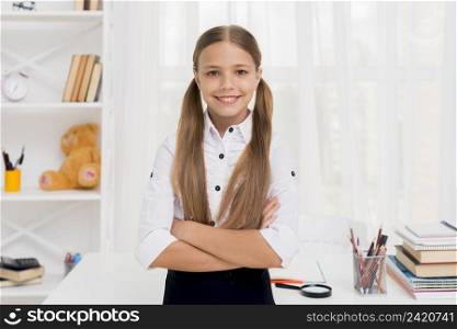 smiling elementary school girl standing with arms crossed