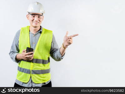 Smiling engineer holding cell phone and pointing an advertisement. Young latin engineer holding phone and pointing at blank space