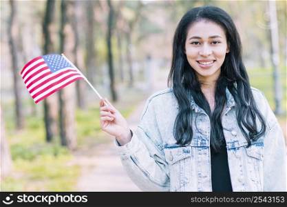 smiling ethnic female waving american flag