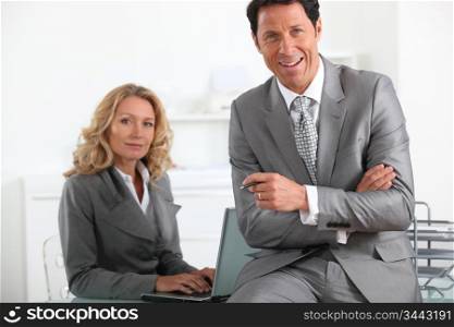 Smiling executives with laptop computer
