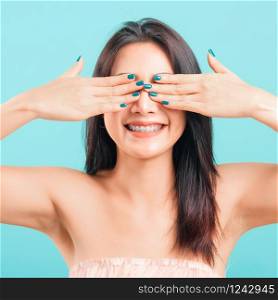Smiling face Asian beautiful woman her covering eyes by hands on blue background,