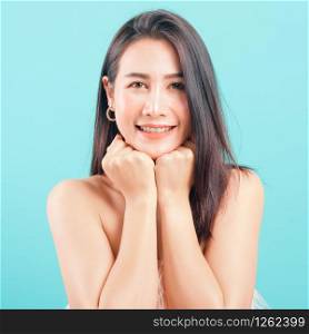 Smiling face Asian beautiful woman her glad keeps both hands under chin smiles pleasantly on blue background