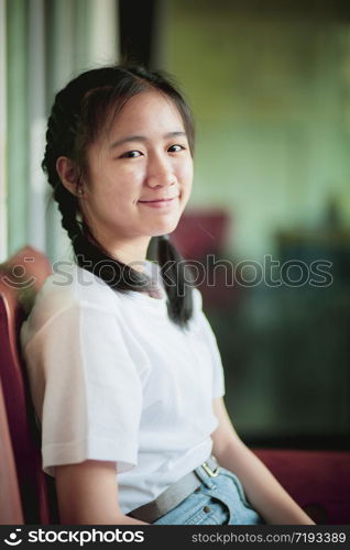 smiling face asian teenager sitting home living room