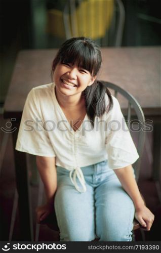 smiling face asian teenager sitting home living room