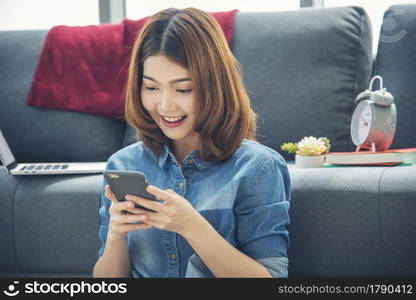 Smiling face asian woman holding smartphone with E-commerce Shopping online website Reading Online Article, Blog, vlog. Young Woman hands holding phone technology lifestyle. Woman using smart phone.