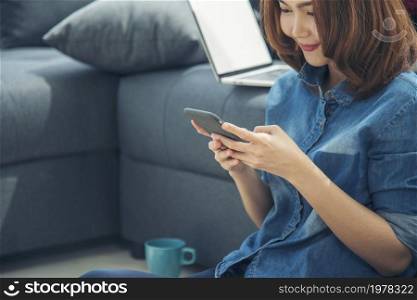 Smiling face asian woman holding smartphone with E-commerce Shopping online website Reading Online Article, Blog, vlog. Young Woman hands holding phone technology lifestyle. Woman using smart phone.