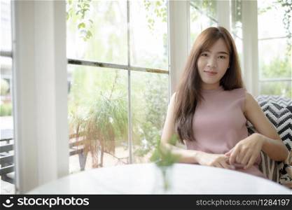 smiling face beautiful asian younger woman relaxing in living room