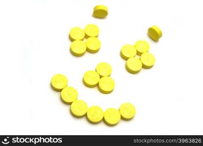 Smiling face pills on white background
