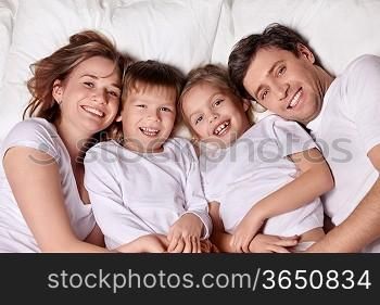 Smiling family in bed