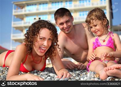 smiling family on pebble in swimwear