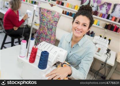smiling fashion designer using sewing machine
