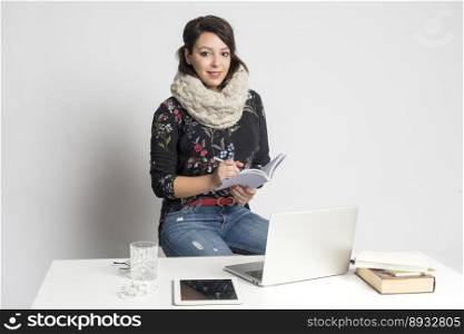 Smiling fashion designer woman working on laptop at creative office