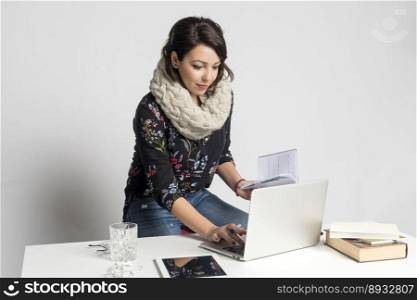 Smiling fashion designer woman working on laptop at creative office
