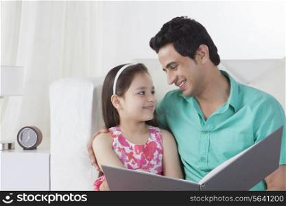 Smiling father and daughter with file looking at each other