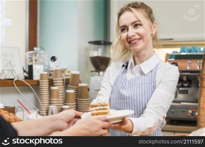 smiling female baker serving pastry cake customer