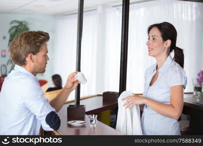 smiling female barista and handsome client at counter