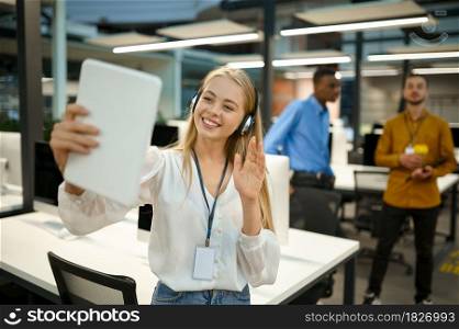 Smiling female manager holds laptop, video conference in IT office. Professional worker, planning or brainstorming. Successful employee in modern company. Manager holds laptop, video conference, IT office