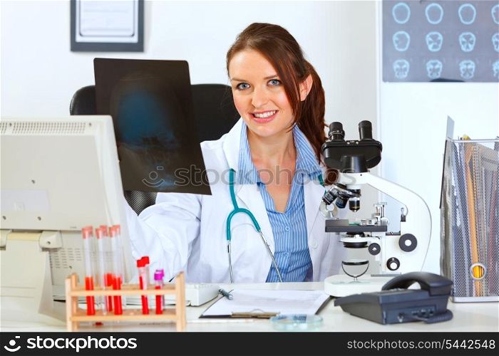 Smiling female medical doctor sitting at table with patients roentgen&#xA;