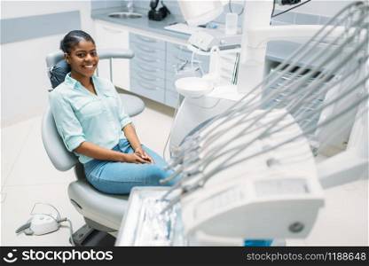 Smiling female patient on chair, visit in dental clinic. Woman in dentistry cabinet, stomatology, tooth care. Smiling female patient on chair, dental clinic