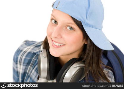 Smiling female teenager enjoy music with headphones and baseball cap