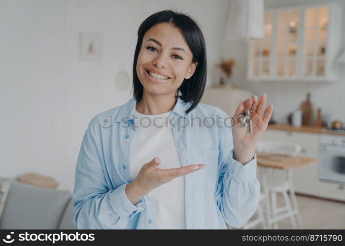 Smiling female tenant or homeowner showing keys to new home. Happy woman renter holding key to apartment, looking at camera. Real estate sale. Rental service, mortgage advertisement.. Smiling female tenant homeowner showing keys to new home. Real estate rental. Mortgage advertisement