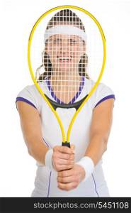 Smiling female tennis player looking through racket