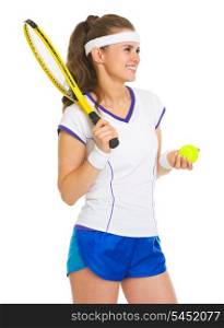Smiling female tennis player with racket and ball looking on copy space
