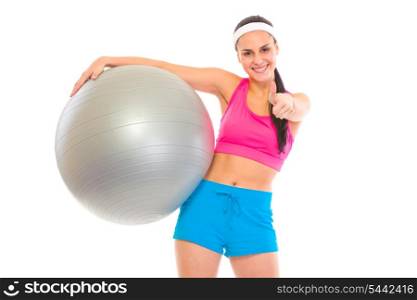 Smiling fit young girl with fitness ball showing thumbs up gesture isolated on white&#xA;