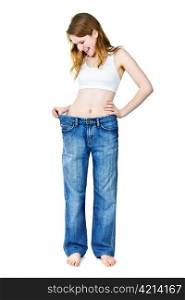 Smiling fit young woman in loose old jeans after losing weight isolated on white