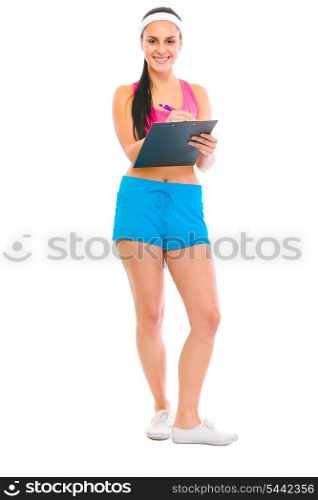 Smiling fitness girl writing on clipboard