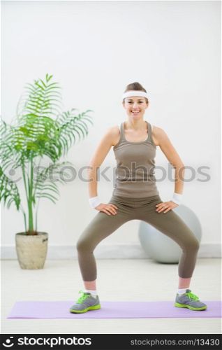 Smiling fitness woman making stretching exercises