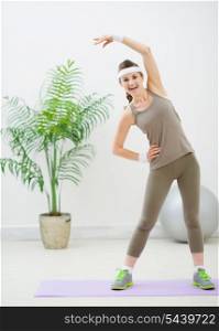 Smiling fitness woman making stretching exercises