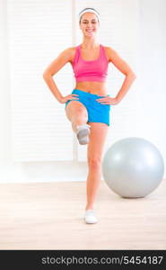 Smiling fitness young girl doing exercises at living room&#xA;