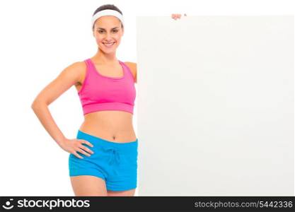 Smiling fitness young girl in sportswear holding blank billboard isolated on white&#xA;