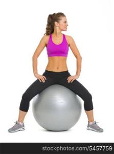 Smiling fitness young woman on fitness ball looking on copy space